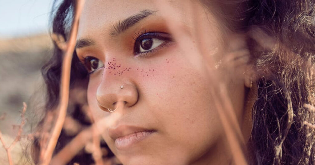 Young Indigenous Native American Woman standing in a field.