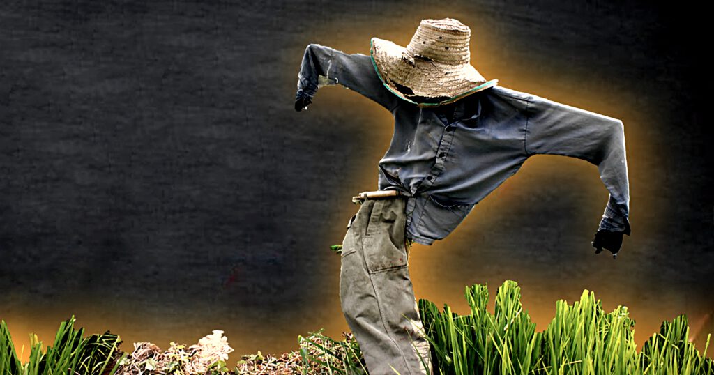 Scarecrow in a field with a dark, ominous sky