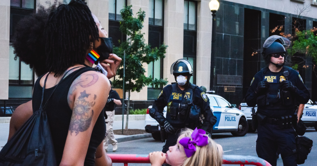 Protesters kept back by police. Photo by Gayatri Malhotra on Unsplash.