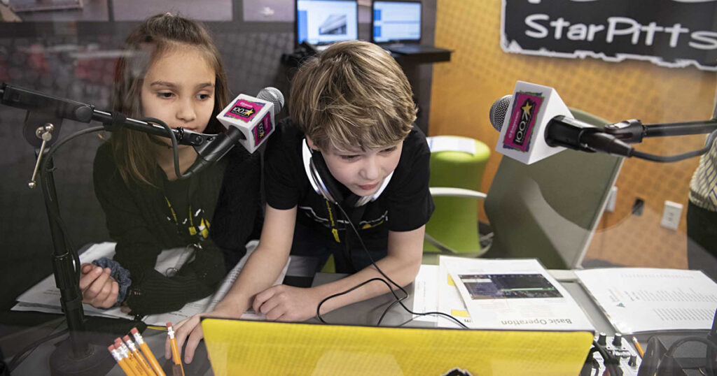 Young boy and girl producing a radio show in a studio