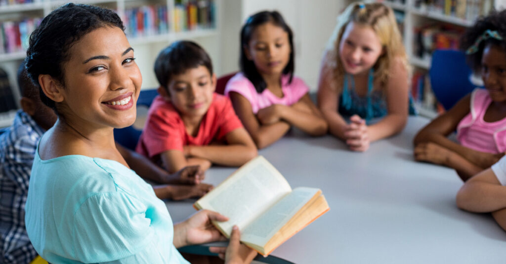 Pupils listening to their teacher reading in the library