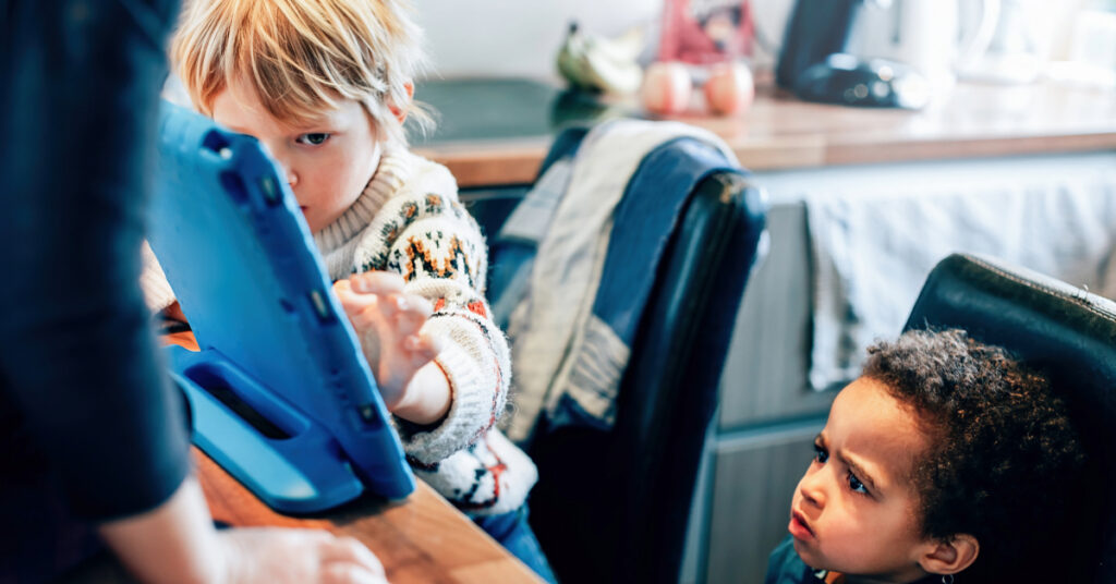 multiethnic children using tablet in the home kitchen