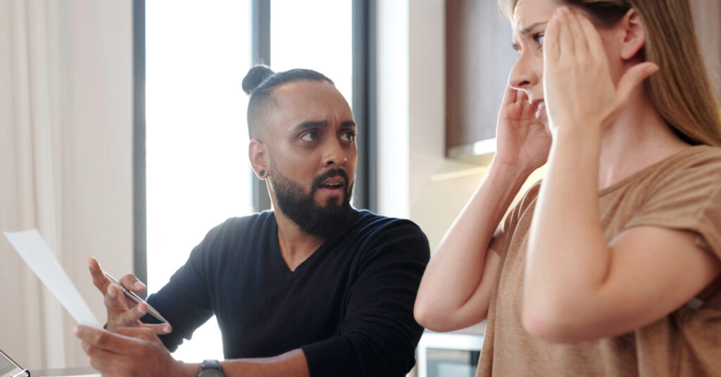 Emotional Man with Bill in hands Looking at Wife