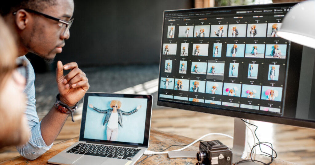 Two photographers working on the computers in the studio