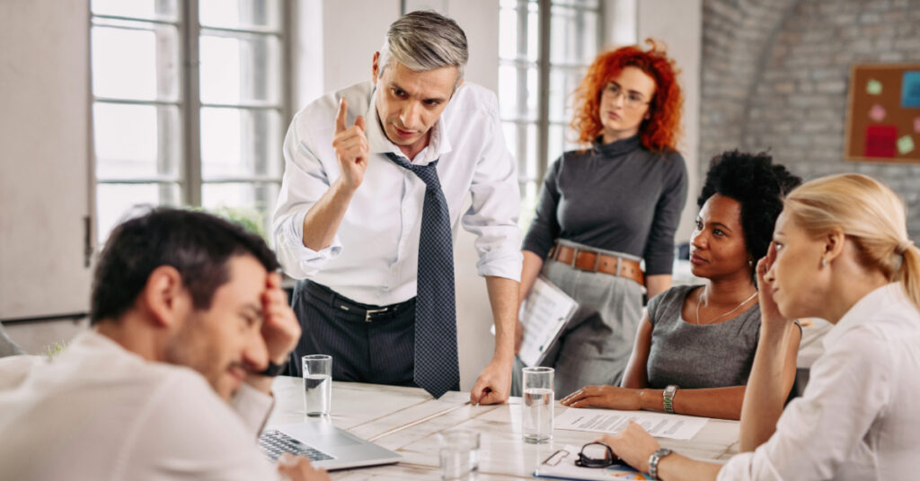 Displeased man arguing with colleagues in a meeting