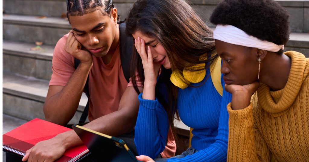 Students sharing bad news on tablet feeling disappointed