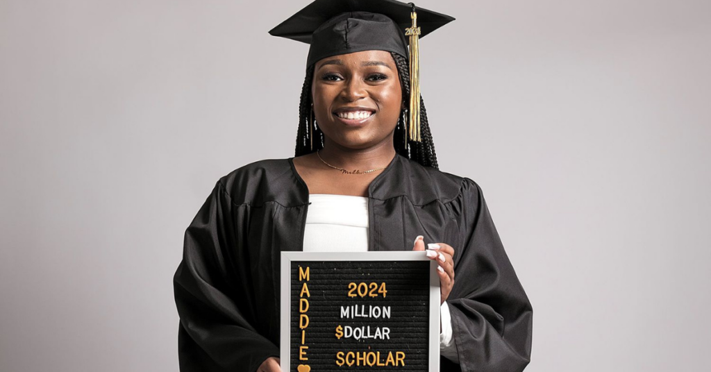 Madison Crowell in black graduation regalia, holding a sign that says "2024 Million Dollar Scholar"