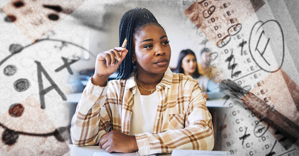 Pensive black female students sitting at a desk in a classroom.