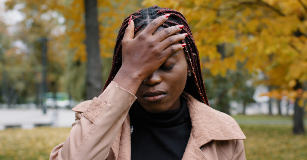 Young distressed african american woman puts palm on head in frustration