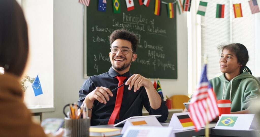 Smiling Black Male Teacher Talking to Black Students at Civics Lesson