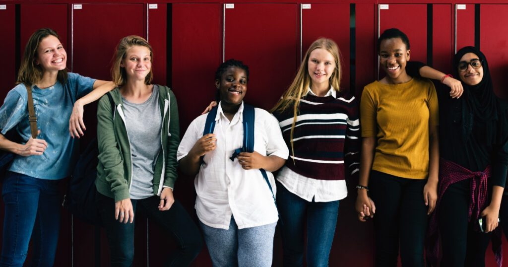 Friends standing together in front of lockers at school