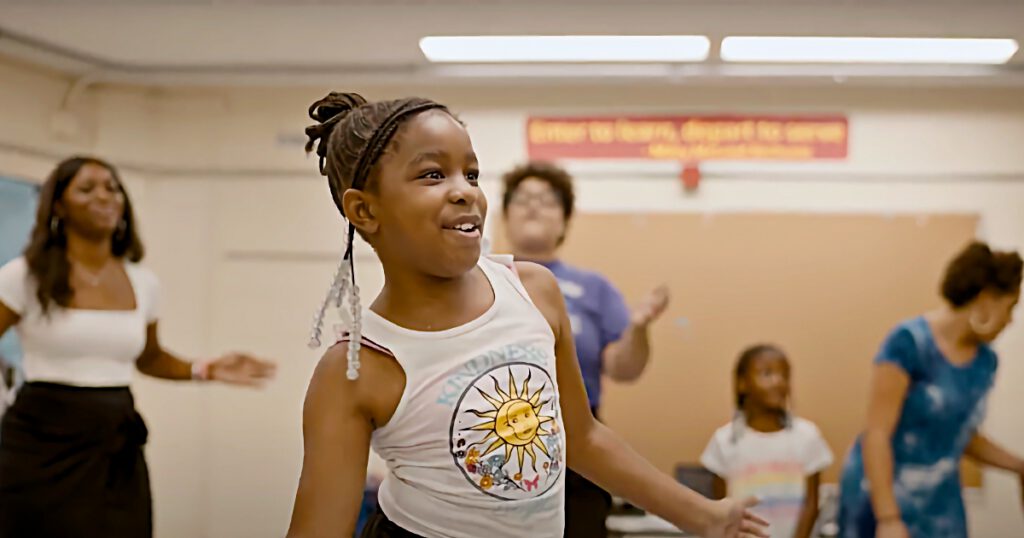 Young Black girl dancing and singing with her class at a Philadelphia Freedom School