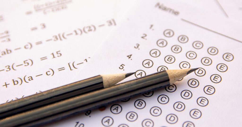 Two black, sharpened pencils on top of a standardized test answer sheet