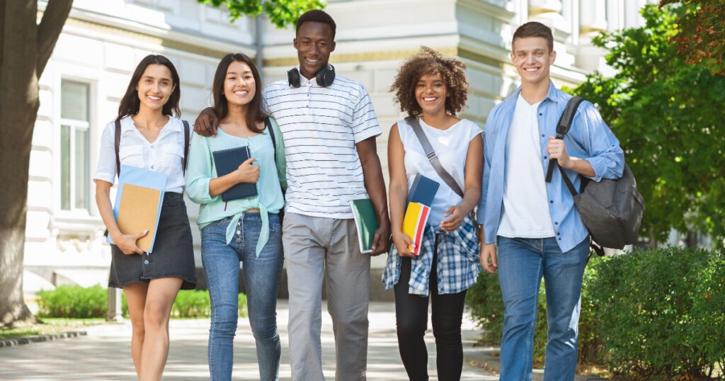 Happy Diverse College Friends Walking on Campus And Smiling To Camera