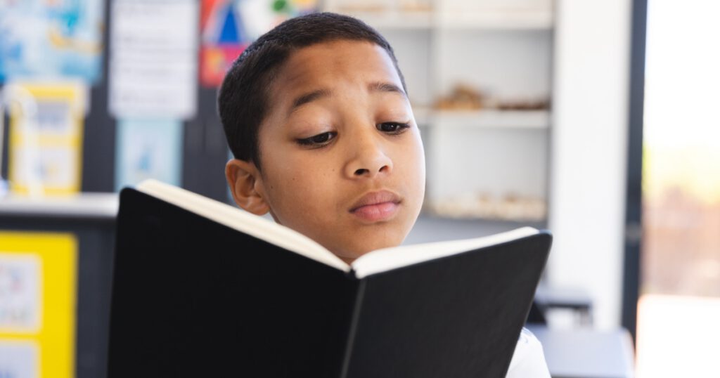 Biracial boy engrossed in reading a book