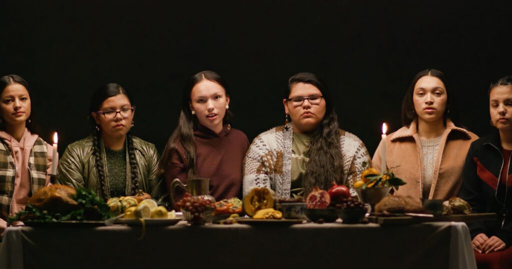 Young Indigenous women sitting at a Thanksgiving table; screen grab from Teen Vogue